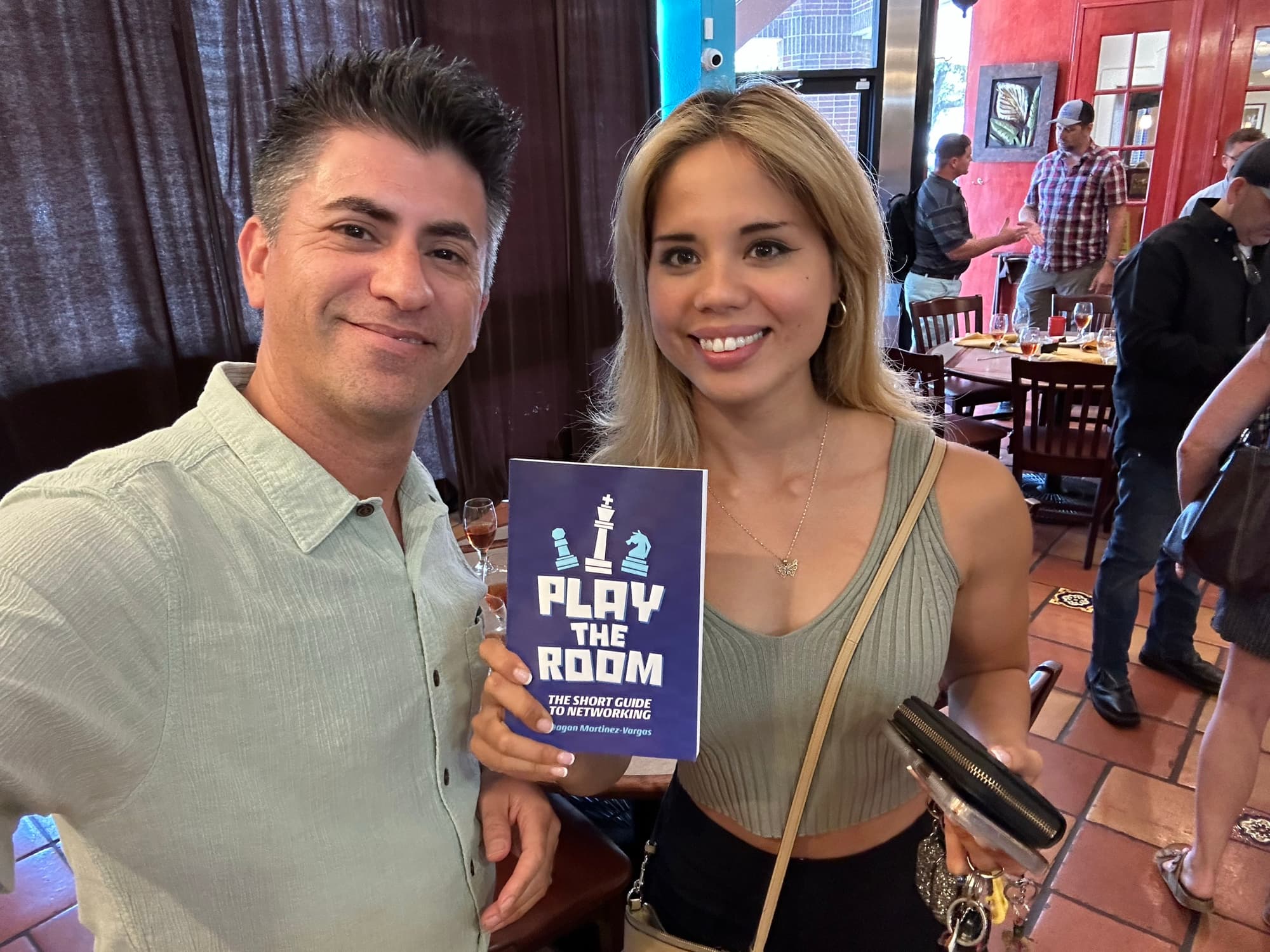 Dagan Martinez-Vargas with a reader holding a copy of Play the Room