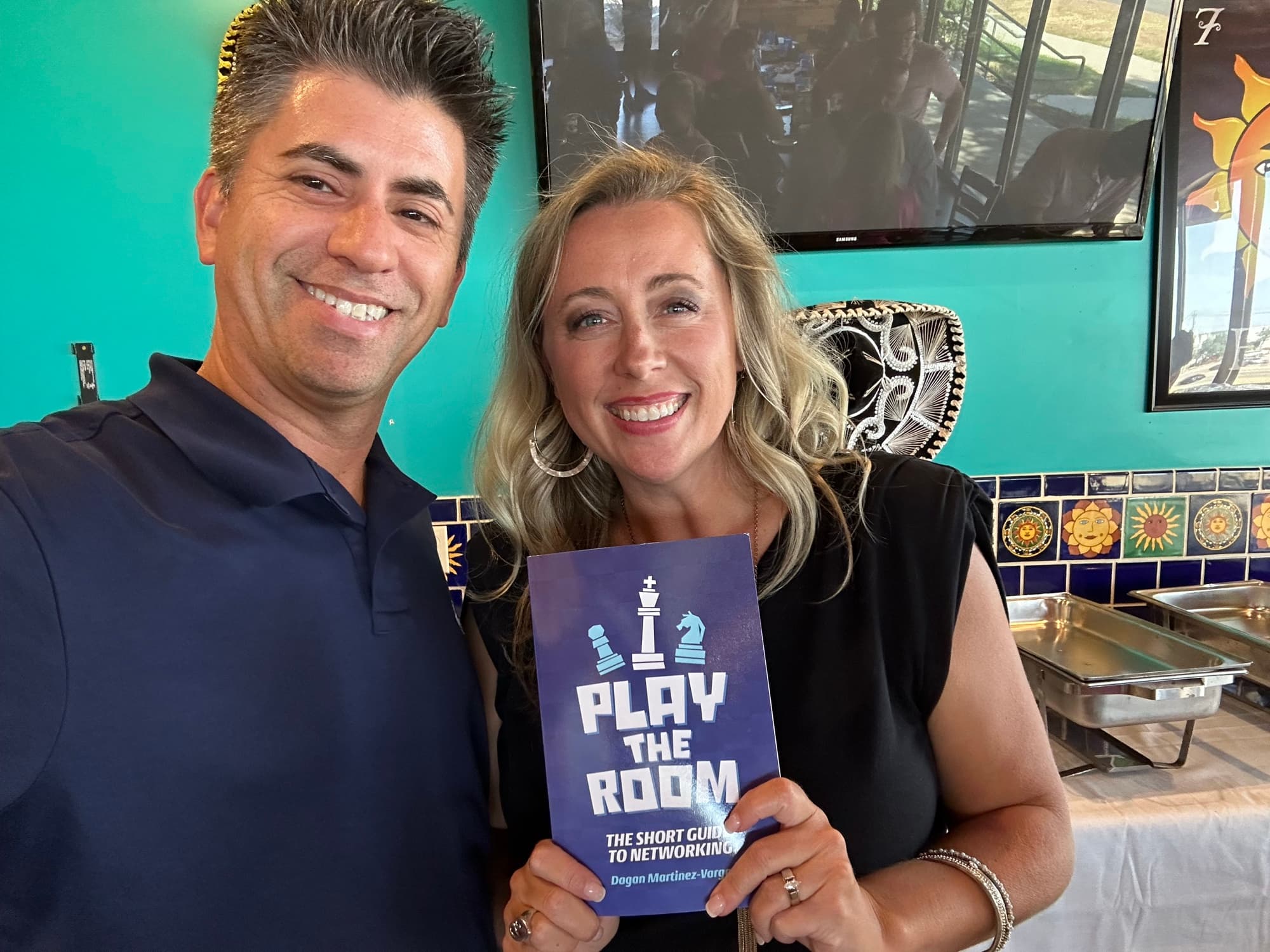 Dagan Martinez-Vargas with a reader holding a copy of Play the Room