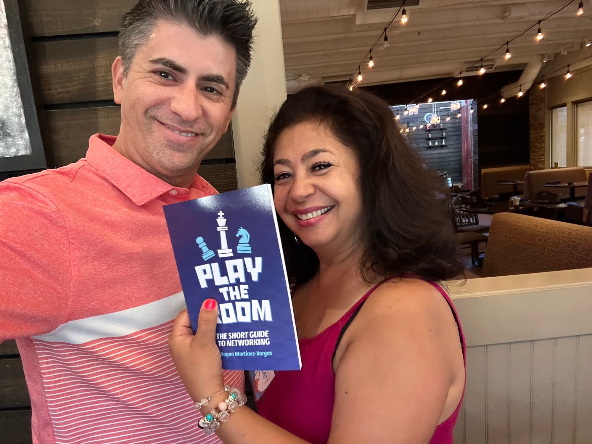 Dagan Martinez-Vargas with a reader holding a copy of Play the Room