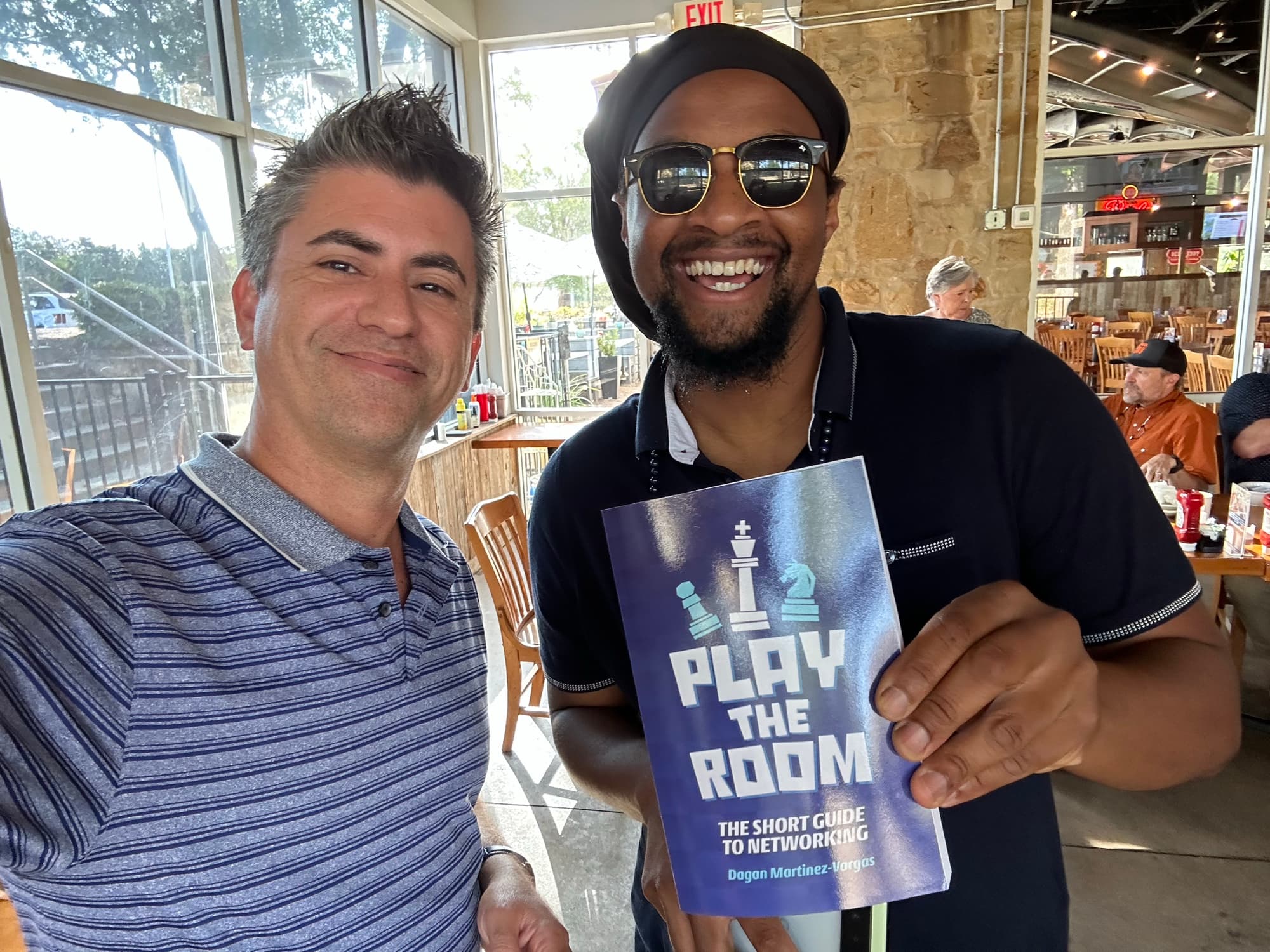 Dagan Martinez-Vargas with a reader holding a copy of Play the Room