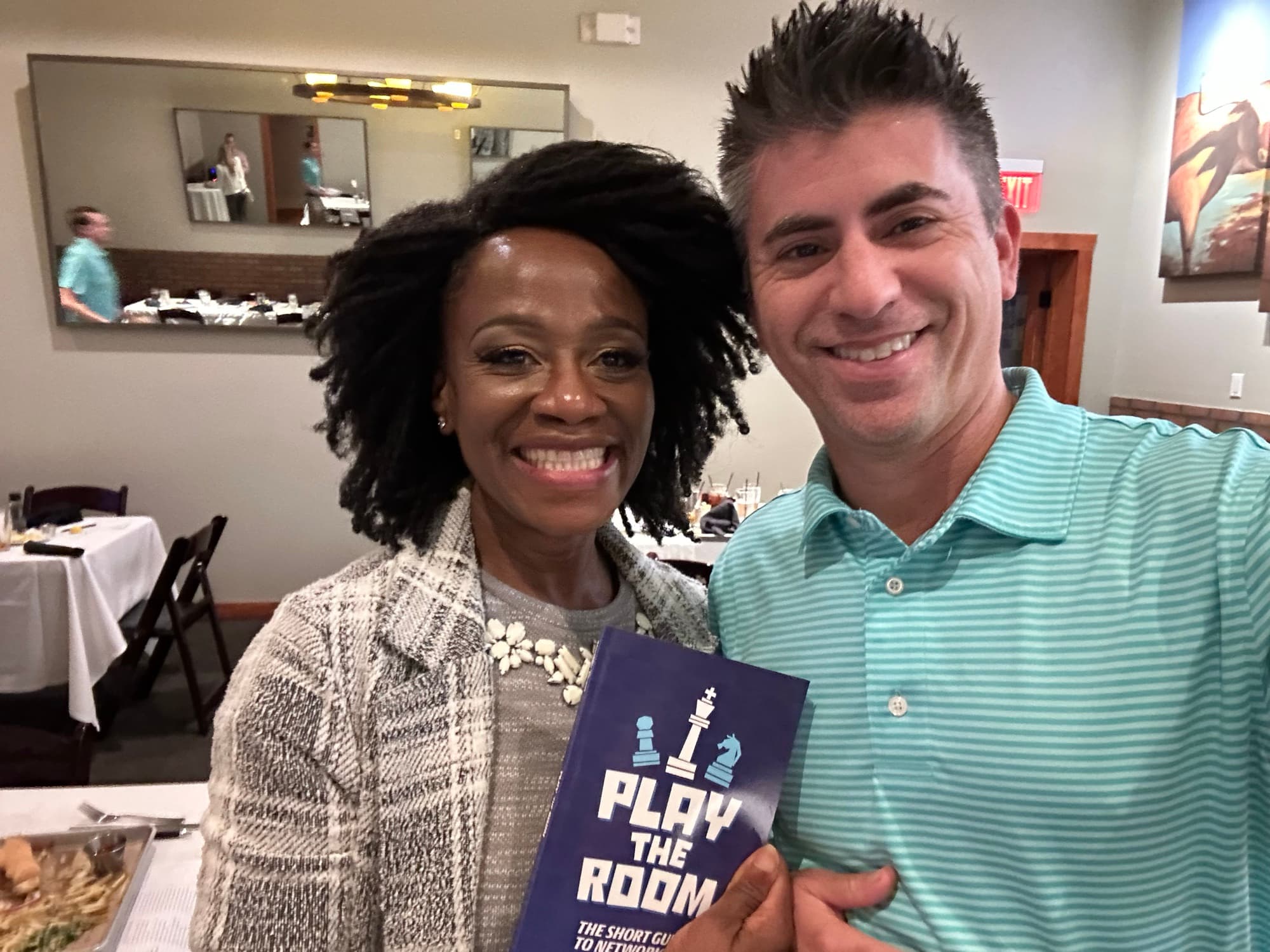 Dagan Martinez-Vargas with a reader holding a copy of Play the Room