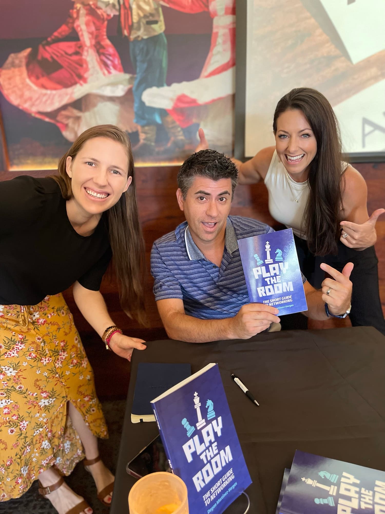 Dagan Martinez-Vargas with a reader holding a copy of Play the Room