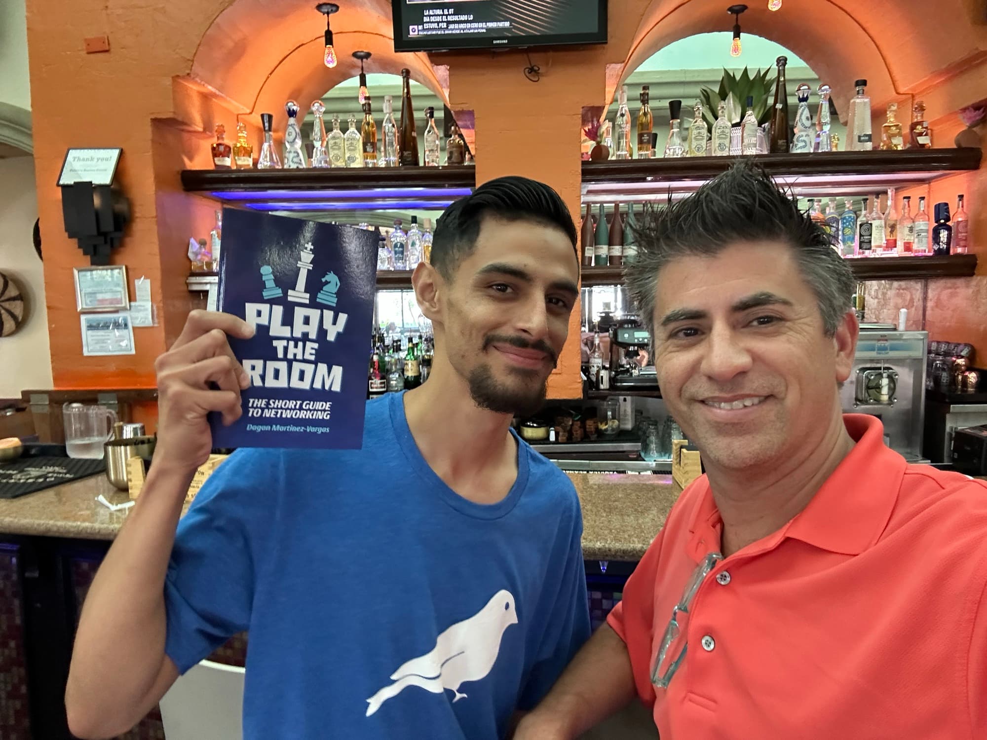 Dagan Martinez-Vargas with a reader holding a copy of Play the Room